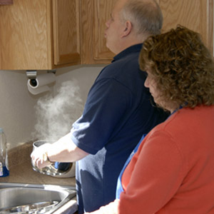 A couple cooks together in their kitchen